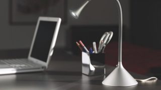 A desk lamp and a laptop sitting on a desk