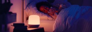 "Smart LED nightlight emitting soft, warm glow as child sleeps peacefully, showcasing customisable bedtime illumination for optimal sleep environment."