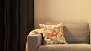 Cosy living room with modern LED table lamp, illuminating grey loveseat and creating warm ambiance for home relaxation.